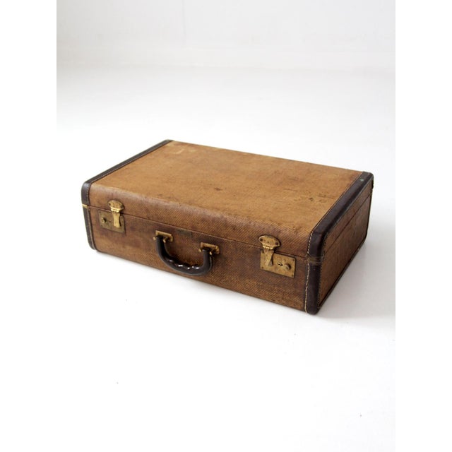A 1950s JC Higgins suitcase with a classic American travel look. The woven tweed exterior, brass-tone hardware, dark brown...