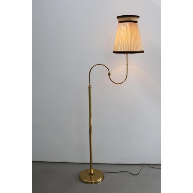 Swedish mid-century brass floor lamp, 1960s. Brass with pleated shade. Height 156 cm. Width with extended swivel arm 58...