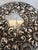 An Antique round handles hand mirror with a beveled mirror. The mirror is sterling silver in an ornate floral repousse...