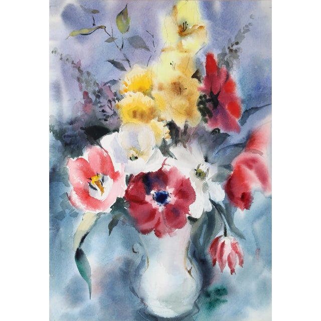 Set against a washed blue and purple background, the white porcelain vase holds a lively bouquet of bright red, pink, and...