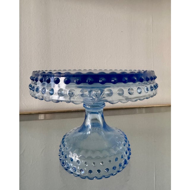 Vintage L E Smith glass hobnail pedestal cake stand. There is a chip on one side (see photo), otherwise, in great condition.