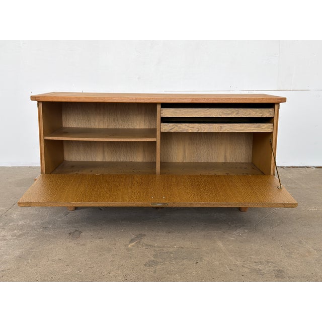 This oak low sideboard/cabinet is designed by Henning Kjærnulf and produced by EG Kvalitetsmøbler in Denmark during the...