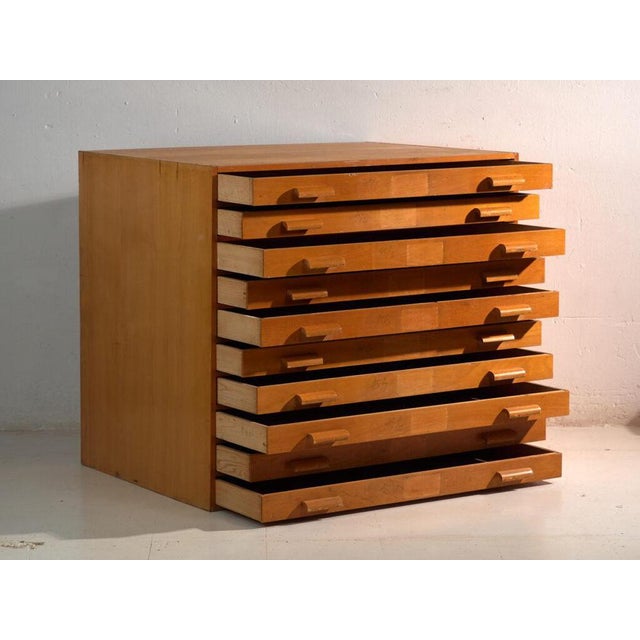 This antique file cabinet in beech wood is a map chest with flat drawers and inset pulls, of cubic body and robust...