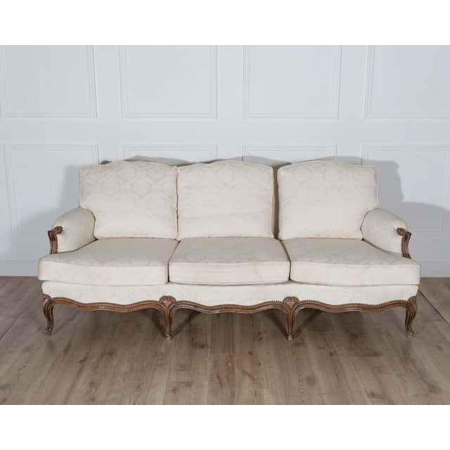 This elegant Louis XV style sofa features a hand carved walnut frame with graceful curves, floral accents, and a deep...