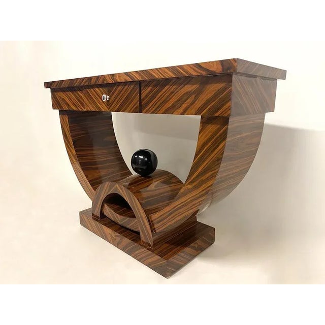 Particularly designed in the mulogan wood, consisting of a drawer. Sfera detail on the base in black lacquered ebanized...