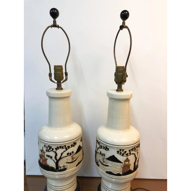 Pair of awesome Midcentury Chinoiserie table lamps beautifully designed in relief each designed with Pagodas, figures and...