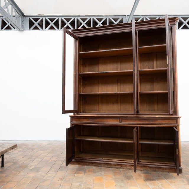 This imposing 19th-century glass-fronted bookcase is primarily crafted from walnut and oak. Its front features three large...