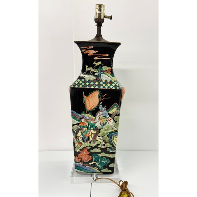 This Chinese Famille Noire porcelain table lamp is a converted vase. The black background has hand painted warrior scenes...