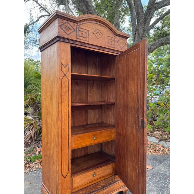 An exceptional antique armoire showcasing beautiful tramp art style carvings and timeless craftsmanship. Rich in character...