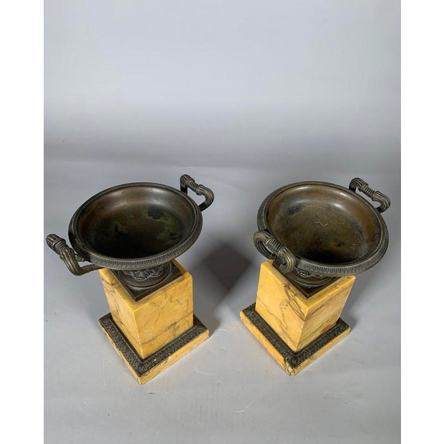 Pair of Charles X period cups in Siena yellow marble. Siena yellow marble base surmounted by antique-style bronze cups...