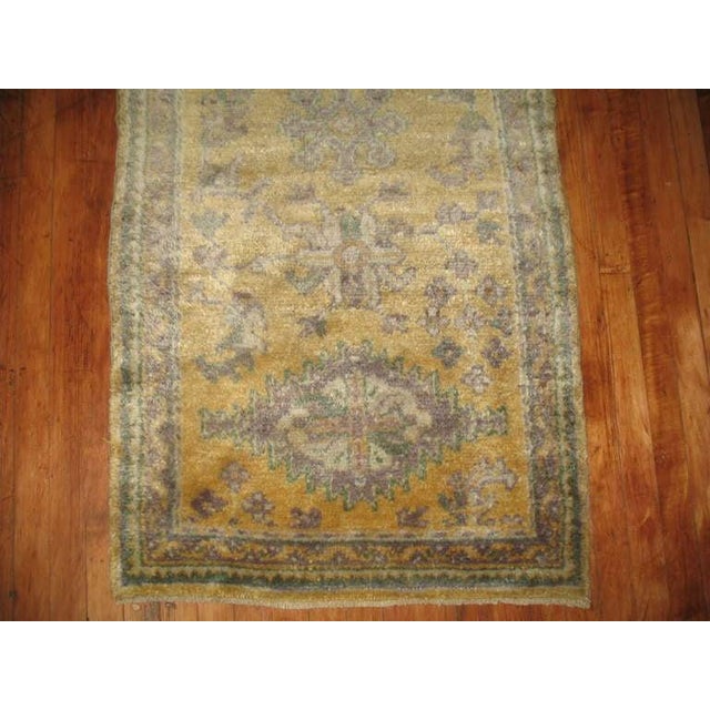 An antique Oushak runner in saffron and chartreuse with shades of lavender. 2'6'' x 11'