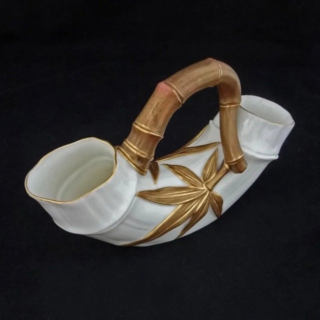 It is open on both ends which lends itself to interesting flower arrangements. The vase's matte, dark copper-tone and gilt...