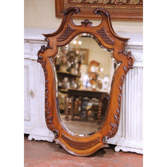 Crafted in England circa 1870, this elegant antique Rococo Revival wall mirror is carved from richly toned walnut and...