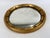 A round giltwood Regency style convex bullseye mirror—sometimes called a porthole mirror—with a broad, reeded gilt frame...