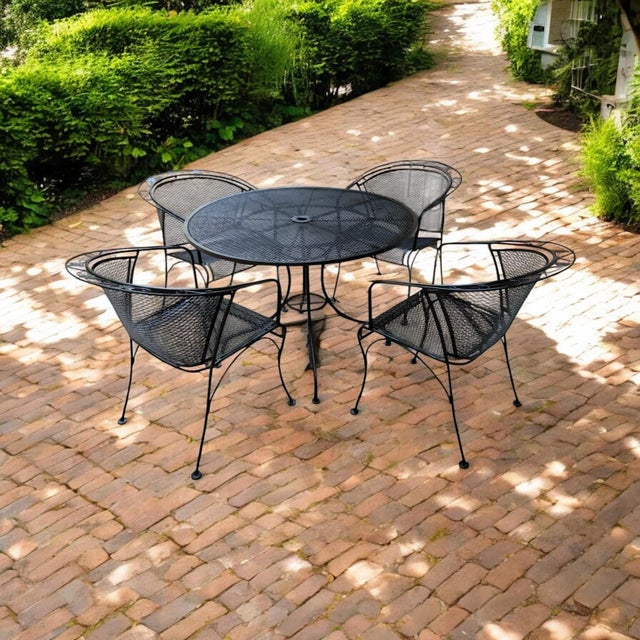 Vintage heavy-duty wrought iron dining set attributed to Russell Woodard, mid-20th century. A round table on a 4-leg...