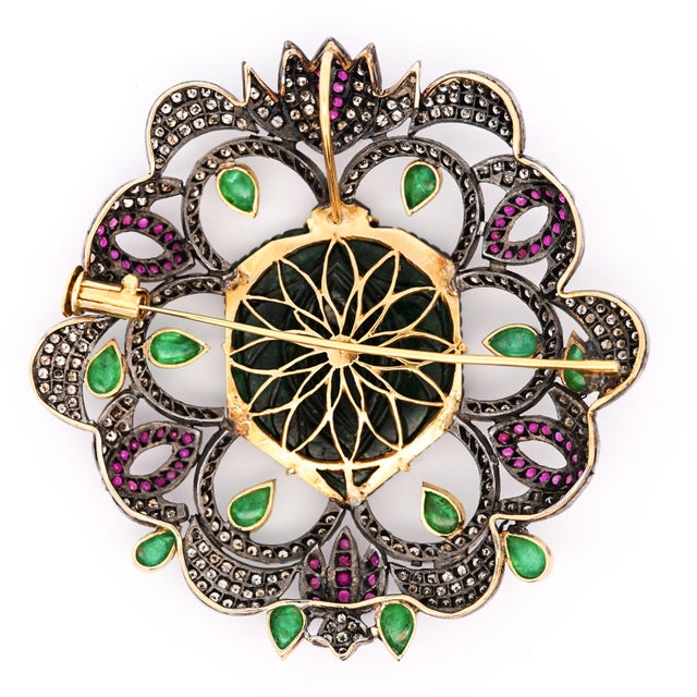 Antique Victorian-era pendant brooch in white and yellow gold featuring a hand-carved jade flower centerpiece surrounded...
