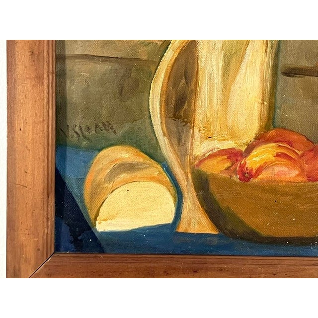 A charming mid-century still life oil on board by V. Sloan, depicting a rustic kitchen scene with bread, ripe peaches, and...