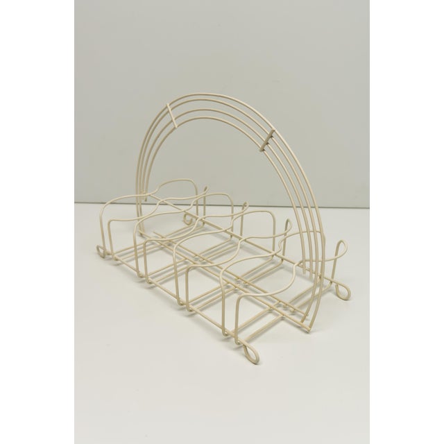 A Mid twentieth century Modern off white finish metal wire caddy for storing 8 tumblers. Featuring an arched handle in the...