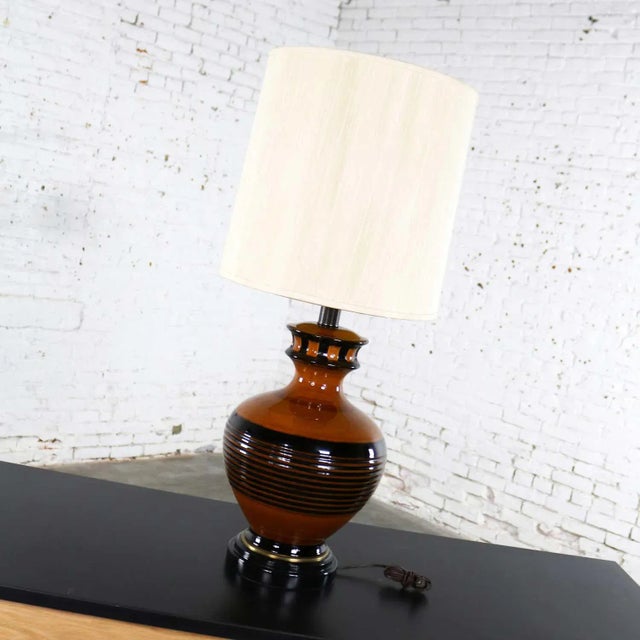 Handsome mid-century modern large brown and black bulbous ceramic lamp. It is in fabulous vintage condition. It wears its...