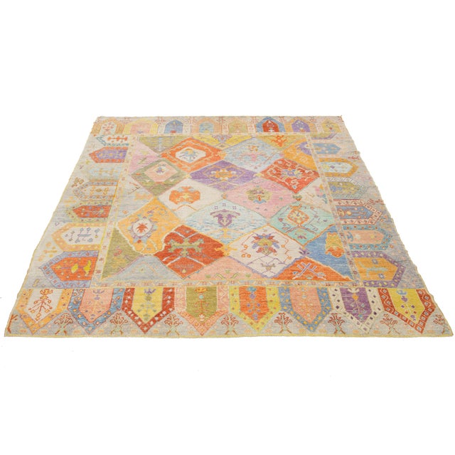 This stunning modern Oushak rug is hand-knotted from soft wool and features a vibrant multicolor field. Adorned with an...