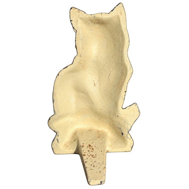 Charming vintage miniature cast iron cat doorstop featuring an expressive face, black pointed ears, creamy yellow body,...