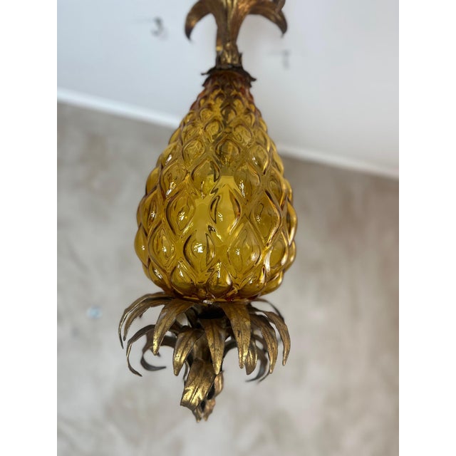 An elegant Italian pendant light from the 1960s, crafted from amber Murano glass and gilt brass, in the refined shape of a...