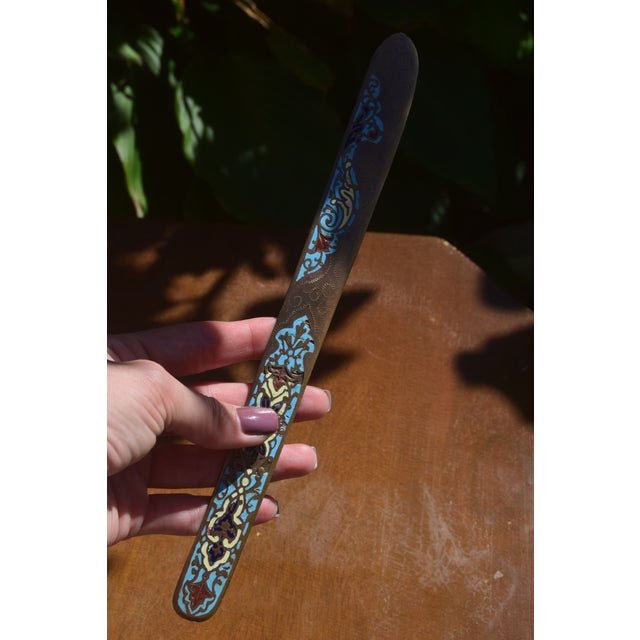 Antique bronze letter opener decorated with colorful champlevé enamel in turquoise, blue, cream, and red, with engraved...