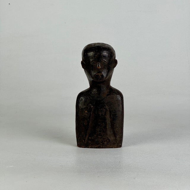 A gorgeous early 20th Century hand carved bust of an African male figure in a most composed and enigmatic pose. The...