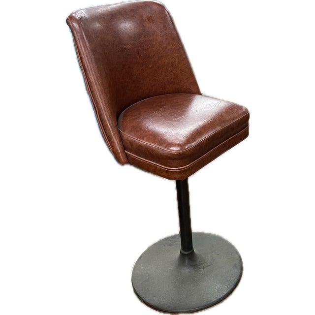 Pair of vintage swivel bar stools with rich brown vinyl upholstery and sturdy black pedestal bases. Classic mid-century...