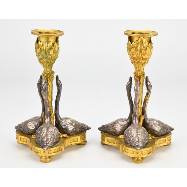 Description - A fine pair of gilt bronze candlesticks with silver git swans, originally designed by William Bateman II for...