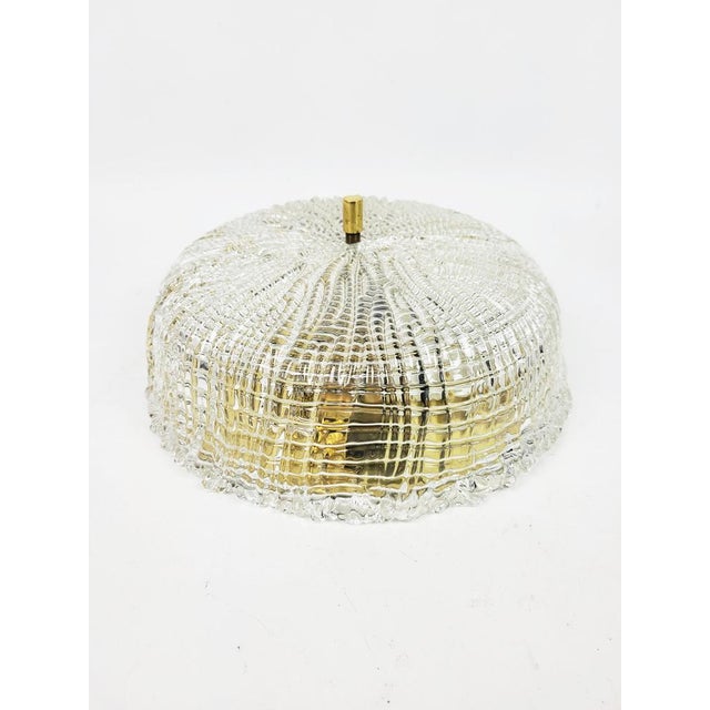 This ceiling lamp by Carl Fagerlund from the "Embassy" series features brass fittings and a lead crystal base, crafted...