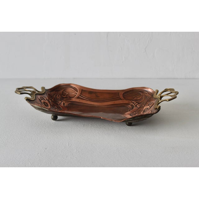 Vintage Art Nouveau embossed copper tray with brass handles in the style of German Carl Deffner in the early 20th century....