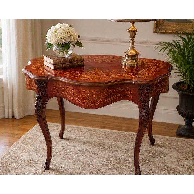 A charming vintage Rococo-style accent table featuring an ornate printed marquetry design across the top and apron,...
