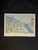 Vibrant framed art poster by Andrea Beloff titled “Island Sunset.” The piece features a tropical coastal village scene...