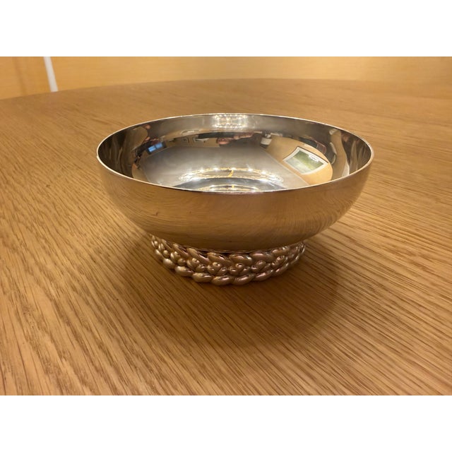 This stylish silver-plated "Babylone" bowl by Christofle, designed by Aurelie Bidermann, rests on a round braided base.and...