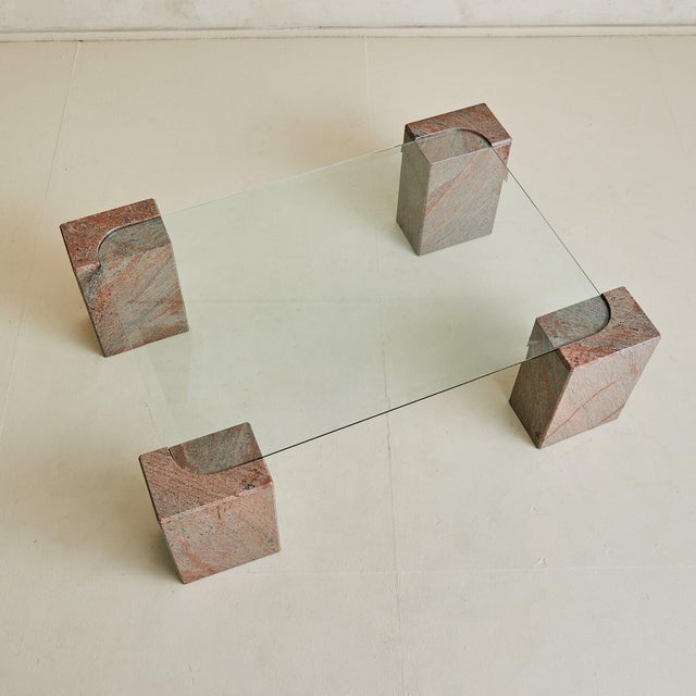 An Italian coffee table from the 1980s, composed of four solid granite blocks veined in dusty rose and slate gray. The...