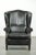 Black cowhide wing armchair in a classic English style, finished with decorative studs. : This black cowhide wing armchair...