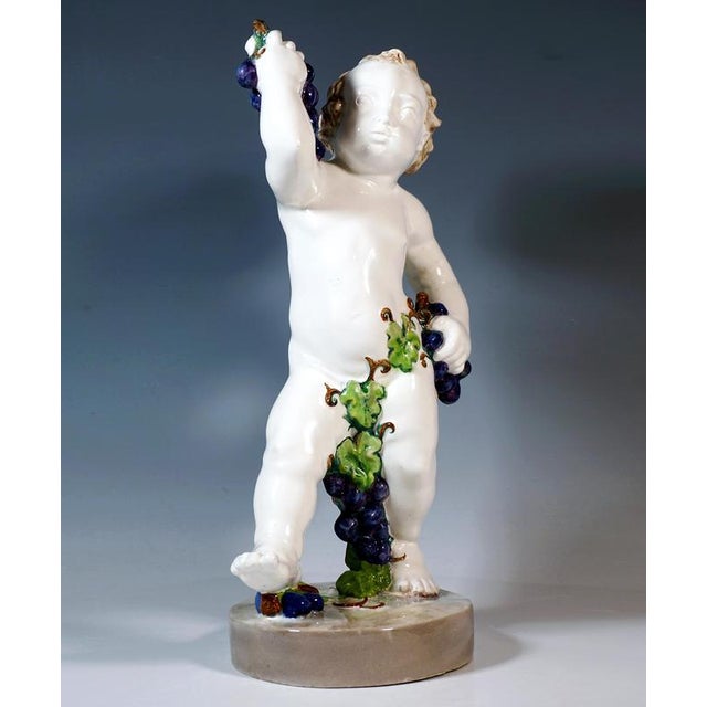Very Rare Goldscheider Figure of the early 1920: Naked putto in a wide stance, curly hair, holding a bunch of blue grapes...