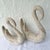 Smaller: 8.5”w, 3.5”d, 10”h A charming pair of postmodern ceramic swan sculptures featuring graceful looping necks and an...