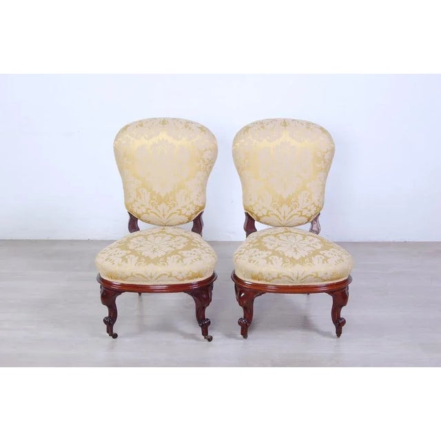 Elegant pair of armchairs design and English production of the early 900s. Wooden structure. Coating in precious damask...