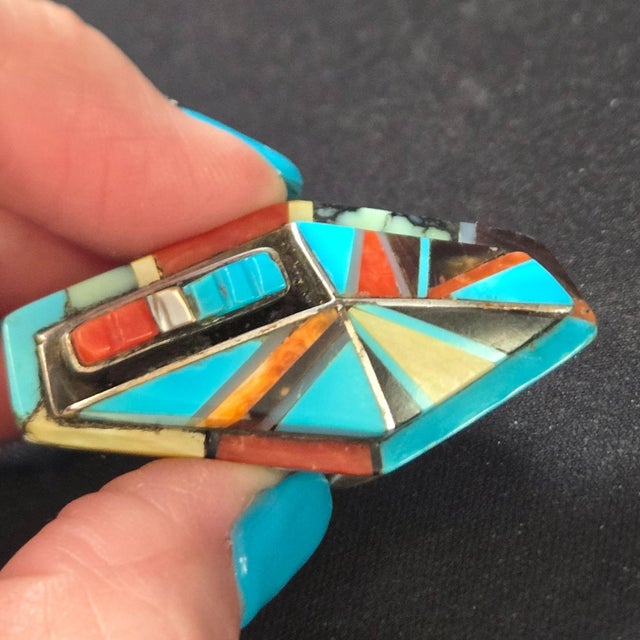 A masterpiece by Navajo artisan Richard Begay, this sterling silver coffin-shaped ring is adorned with intricate inlays of...