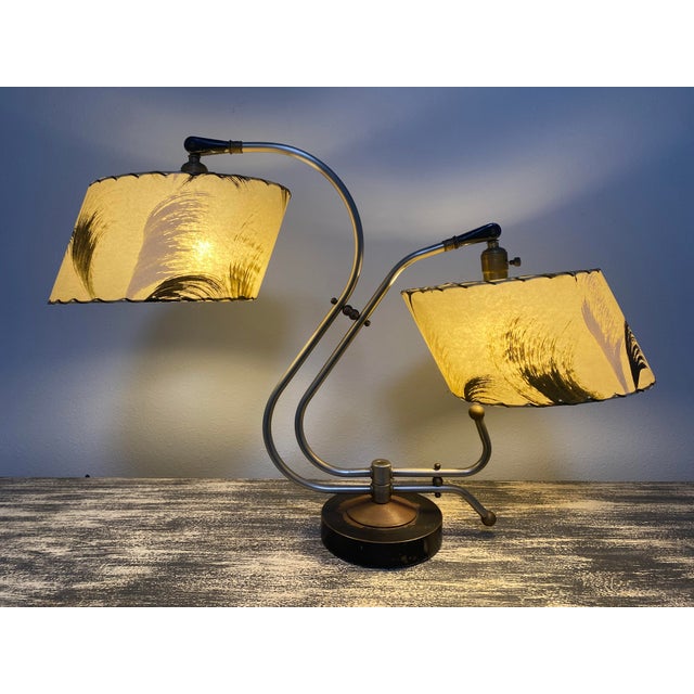 Striking 1950s Atomic Age dual-arm table lamp attributed to the Majestic Lamp Company. The sculptural brass-tone metal...