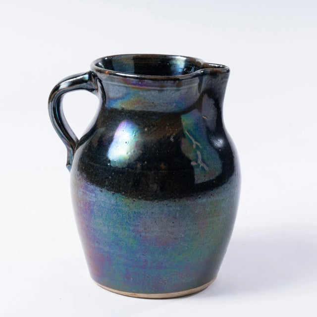 This unique antique stoneware jug has a traditional shape with a dark blue, metallic finish.