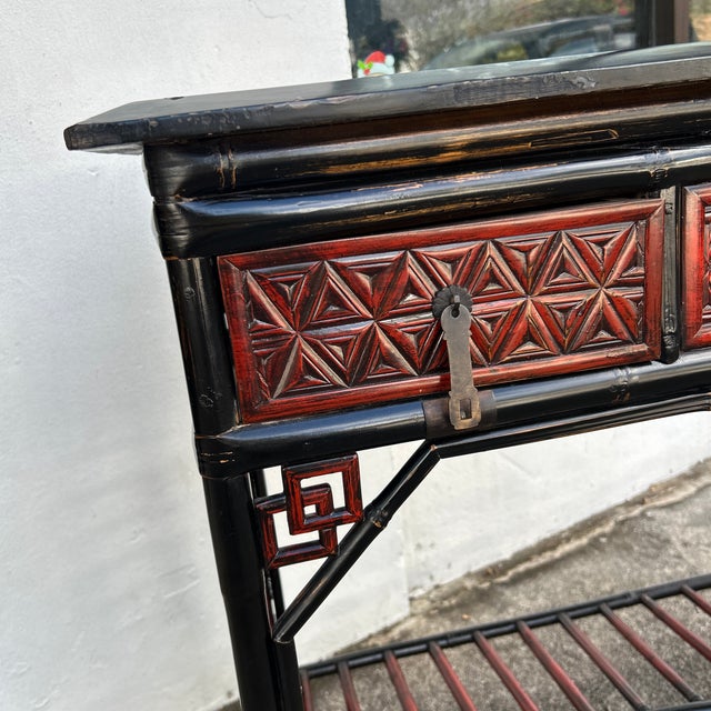 Impressive Antique Chinese desk featuring a lacquer top on a case with three drawers on an ebonized and red lacquer...