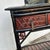 Impressive Antique Chinese desk featuring a lacquer top on a case with three drawers on an ebonized and red lacquer...