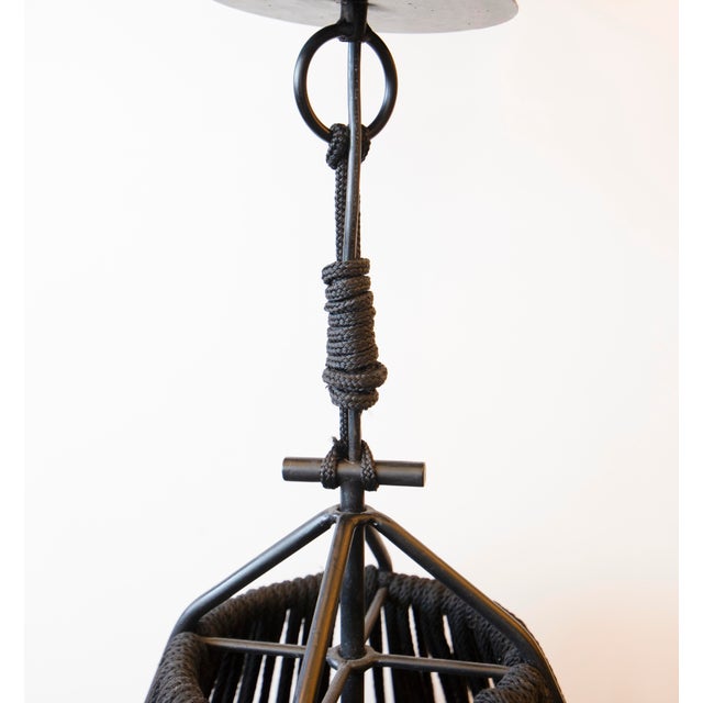 This is a custom hand made light fixture by Artisans. Its made of Black Cotton Rope and Iron. This has a fixed drop. The...