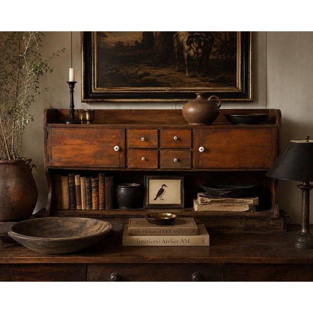 A beautiful antique wood cabinet with a long, low profile, petite drawers, paneled cupboards, and original white porcelain...