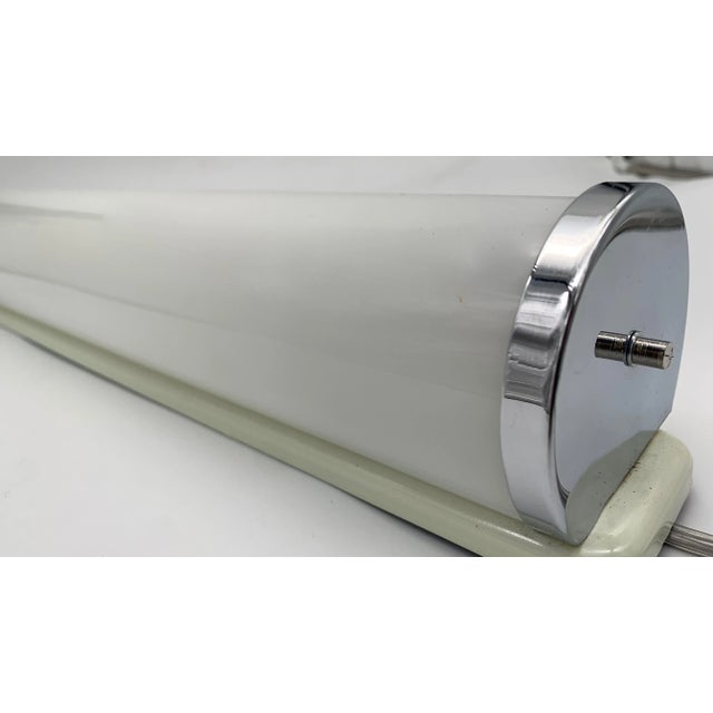 They are a pair of glass wall lights with a modern and linear design, characterized by a horizontal tubular structure that...