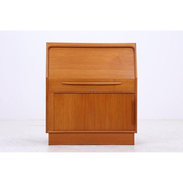 Vintage teak secretary desk by Bernhard Petersen & Søn with a classic drop-front and well-organized interior. Behind the...