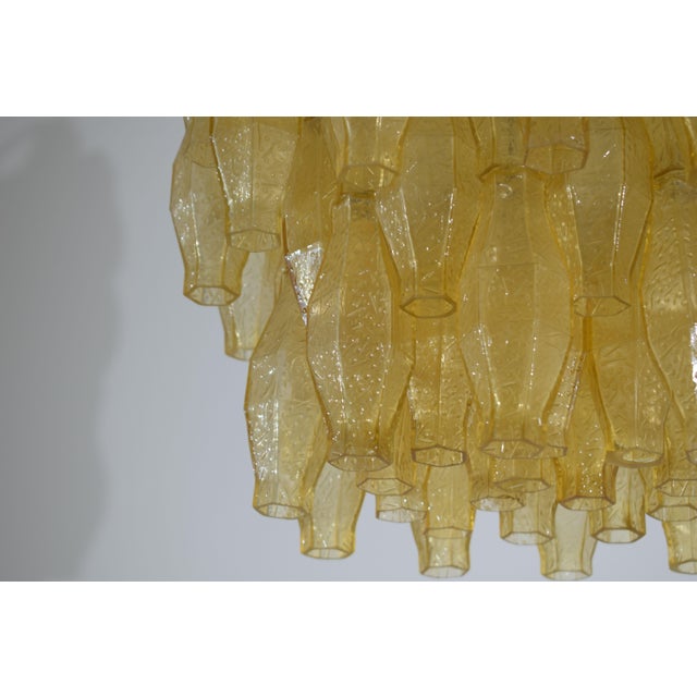 Fascinating amber glass polyhedron chandelier, attributed to Venini, made in Italy in the 1960s. The lacquered metal...